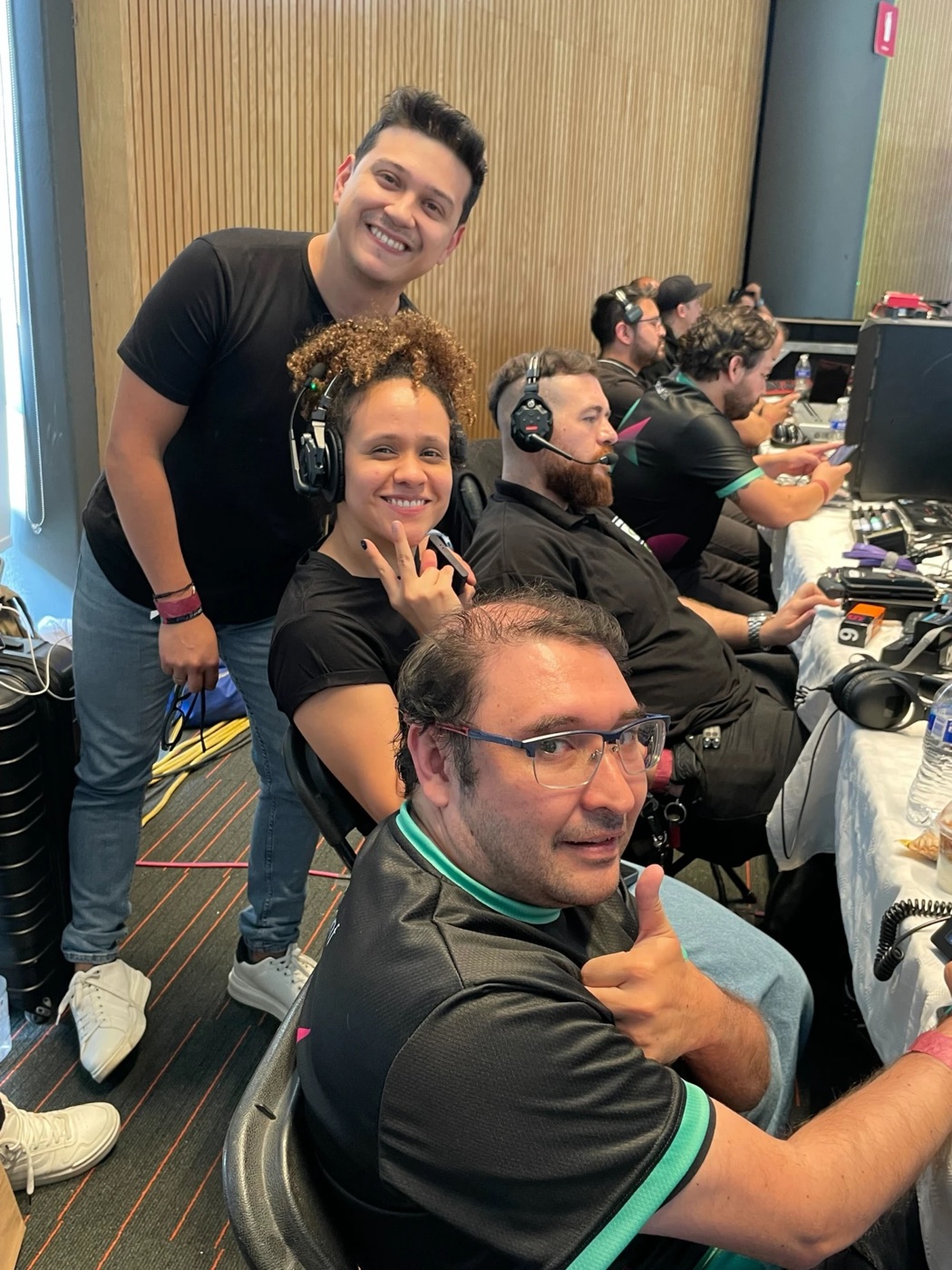 El equipo en la cabina de una transmisión en vivo, sonriendo a cámara