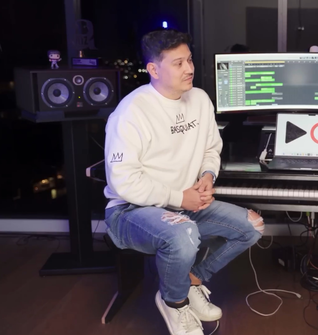 Jorge sentado en su estudio de producción, junto a los monitores y el piano